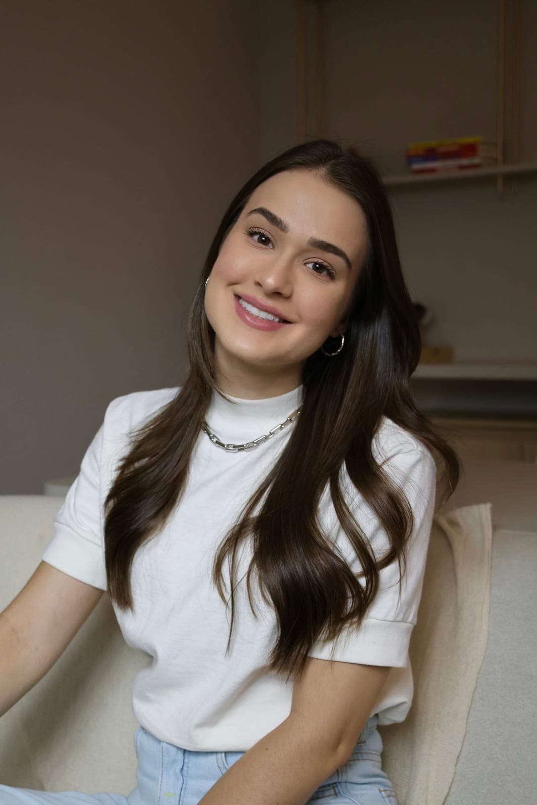 Psicóloga Ana Carolina Crema sorrindo, de camisa branca