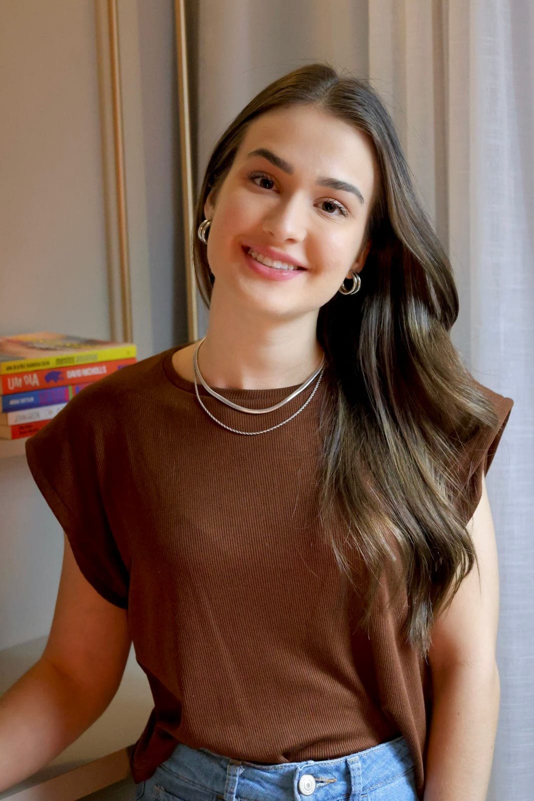 Psicóloga Ana Carolina Crema sorrindo, de blusa marrom