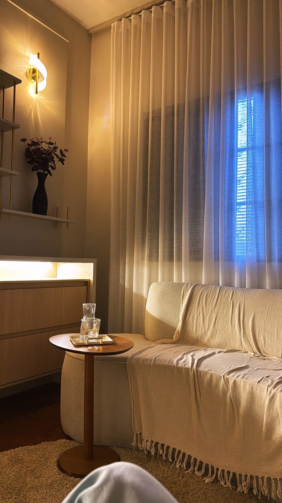 Consultório iluminado, com cortinas e sofá claro