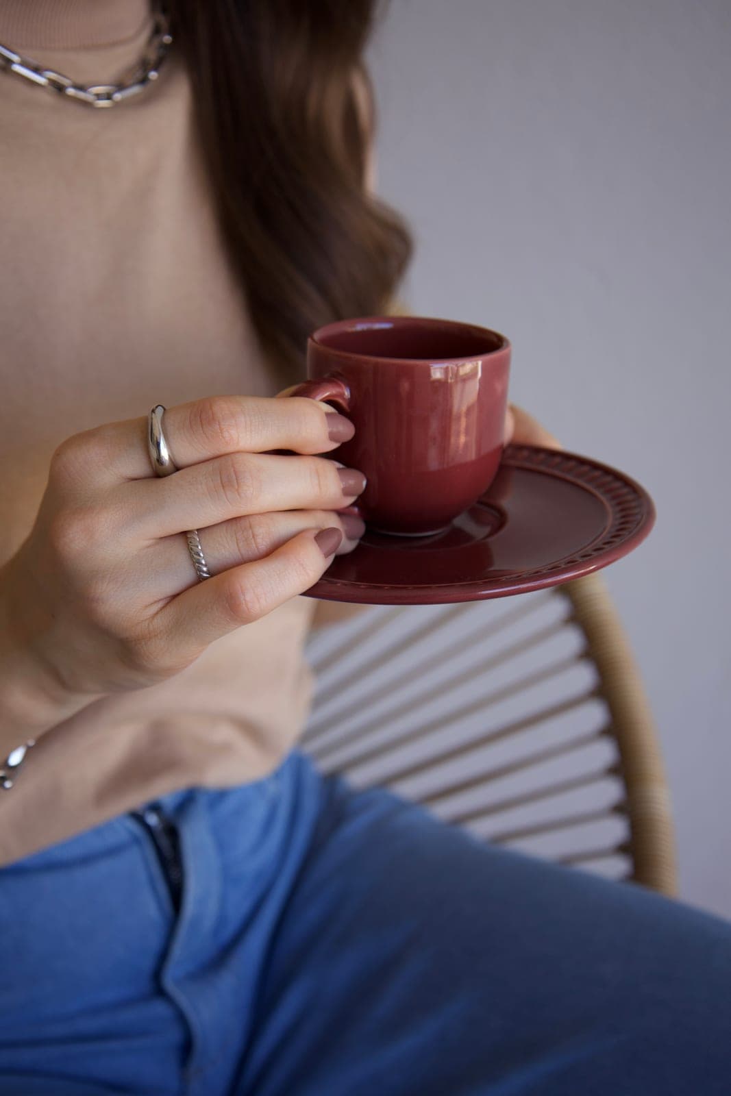 Detalhe de uma xícara de café nas mãos da Carol